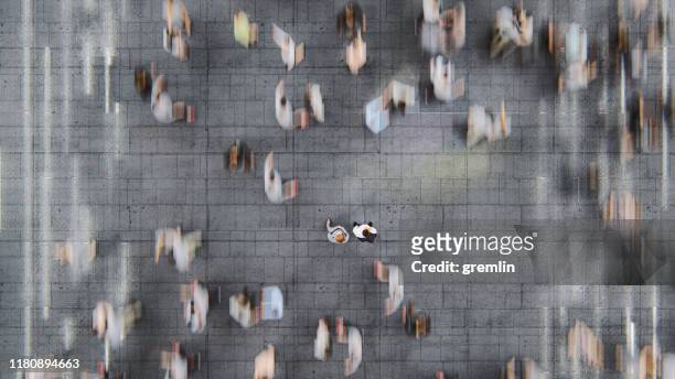 uomo d'affari in piedi tra le folle in rapido movimento di pendolari - overhead view foto e immagini stock