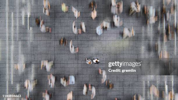 uomo d'affari in piedi tra le folle in rapido movimento di pendolari - in movimento foto e immagini stock