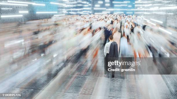 businessman standing in the fast moving crowds of commuters - ignorância imagens e fotografias de stock
