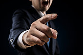 Businessman sticks out a finger and reproves it.