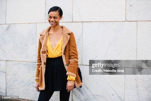 Model Aaliyah Hydes wears a shearling brown jacket, yellow top, and black skirt after the Gabriele Colangelo show on Day 4 Milan Fashion Week...