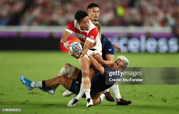 Japan wing Kenki Fukuoka offloads despite the attentions of Scotland centre Chris Harris and Darcy Graham as Yu Tamura looks on during the Rugby...
