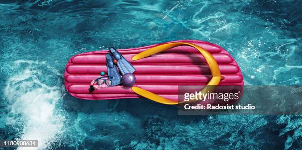 Inflatable floating on water in shape of flip flop.