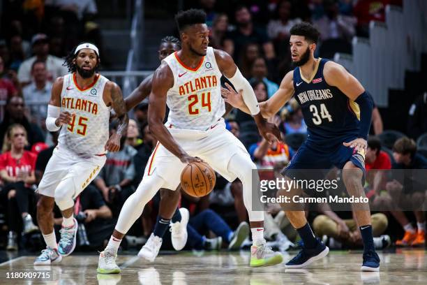Bruno Fernando of the Atlanta Hawks dribbles around defender Kenrich Williams of the New Orleans Pelicans during a preseason game at State Farm Arena...