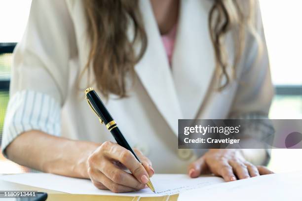 business woman signing documents . deal concept. - deal signing stockfoto's en -beelden