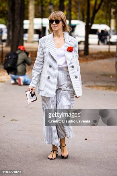 Vika Gazinskaya, wearing a light blue and cream striped suit, is seen outside the Elie Saab show during Paris Fashion Week - Womenswear Spring Summer...