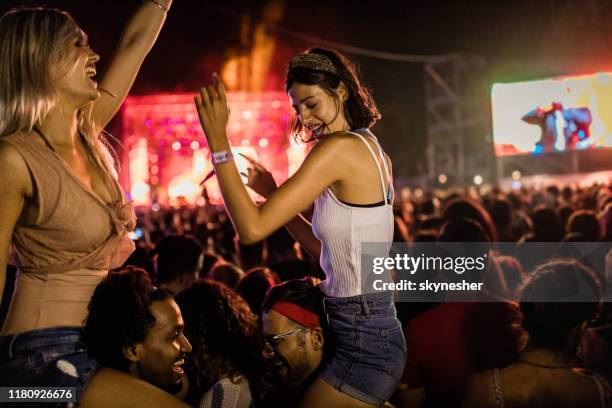 jeunes couples heureux ayant l'amusement sur le festival de musique la nuit. - couple concert photos et images de collection