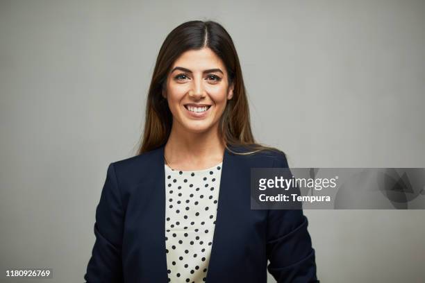 front view of a woman wearing a suit and smiling. - headshot stock pictures, royalty-free photos & images