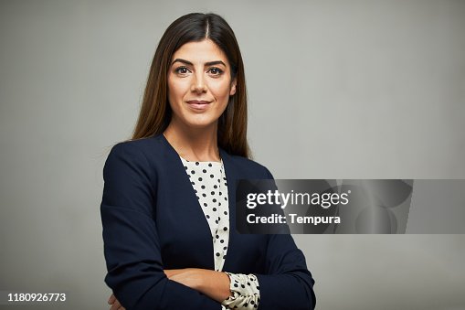 Studio waist up portrait of a beautiful businesswoman with crossed arms. Studio waist up portrait of a beautiful businesswoman with crossed arms.