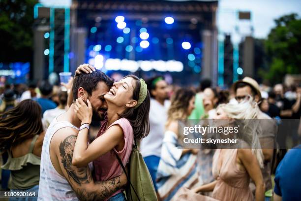 couples embrassés heureux ayant l'amusement sur le concert de musique. - couple concert photos et images de collection