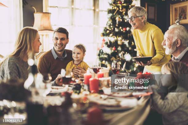 glückliche großfamilie beim mittagessen am neujahrstag zu hause. - table dinner winter stock-fotos und bilder