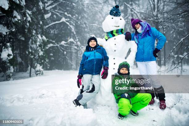 coole kinder und ihr cooler schneemann - schneemann bauen stock-fotos und bilder