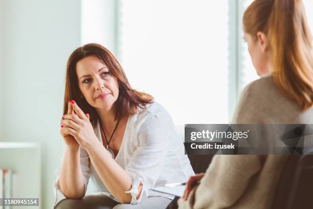 frau mit psychotherapeutin im gemeindezentrum - alternative behandlungsmethode stock-fotos und bilder