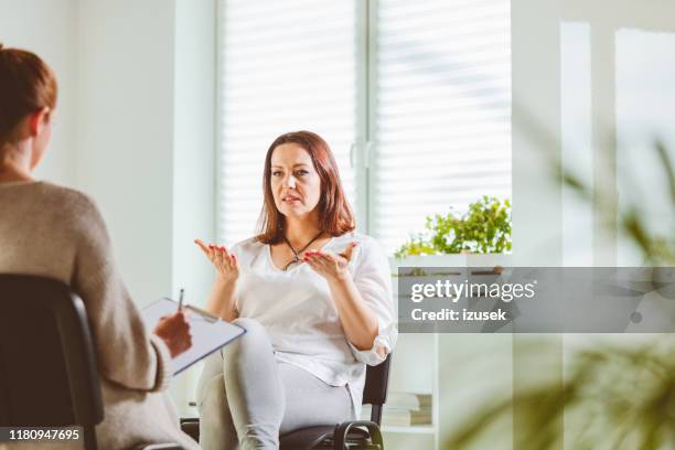vrouw bespreekt problemen met therapeut - negatieve eigenwaarde stockfoto's en -beelden