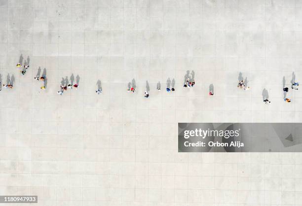 high angle view of people walking on street - städtischer platz stock-fotos und bilder