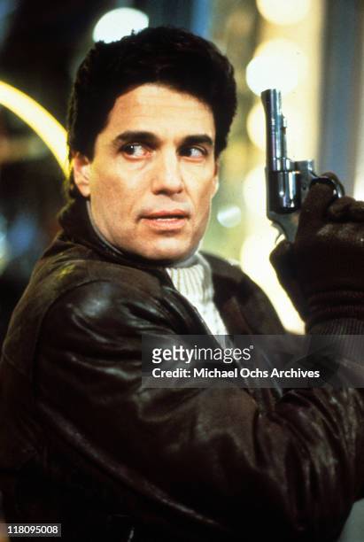Actor Chris Sarandon with gun in a scene from the film 'Child's Play', 1988.