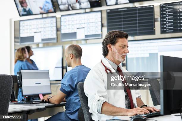 doctors using computers in control room - security system stock pictures, royalty-free photos & images