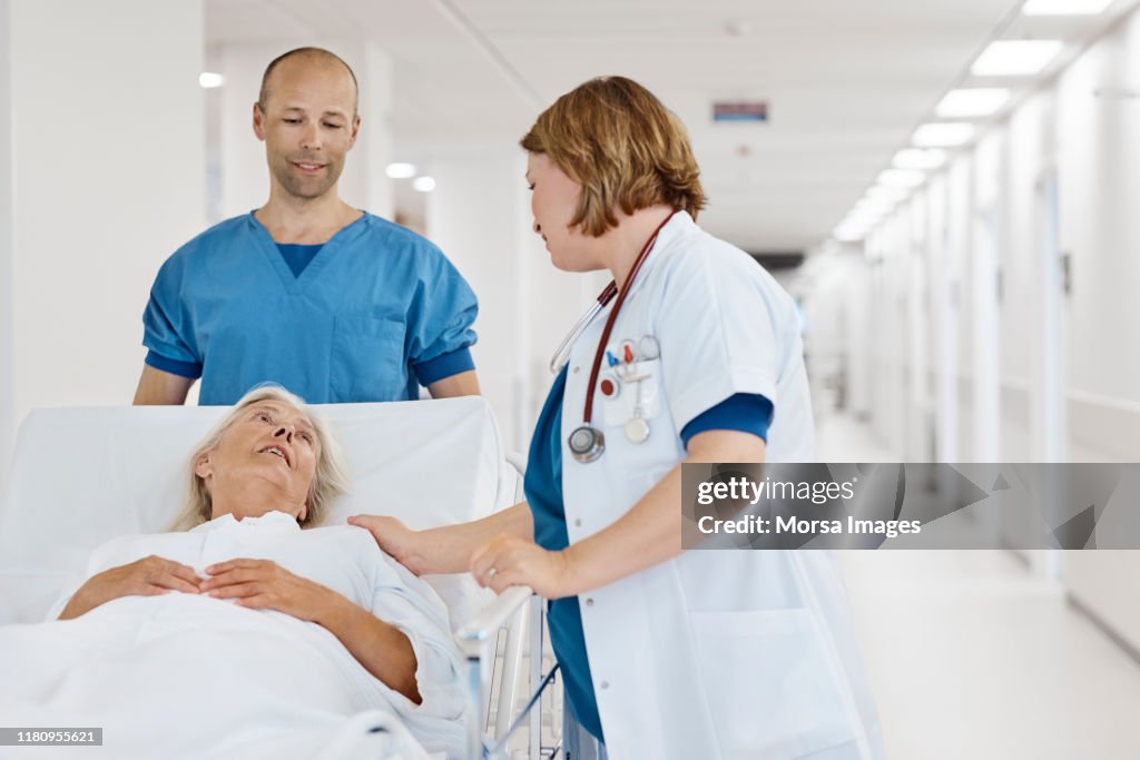 Doctor consoling senior patient at hospital