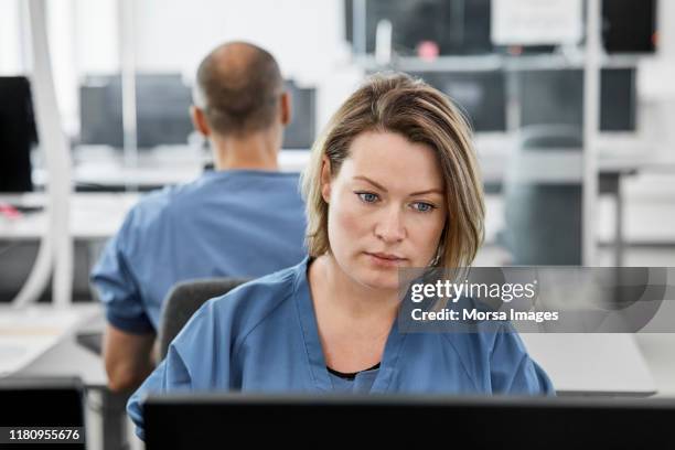 vrouwelijke arts met computer op bureau in ziekenhuis - doctor on computer stockfoto's en -beelden