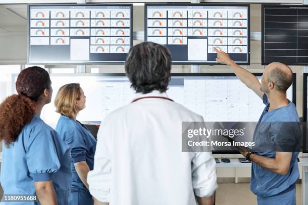 colleagues discussing in meeting at hospital - control room stock pictures, royalty-free photos & images