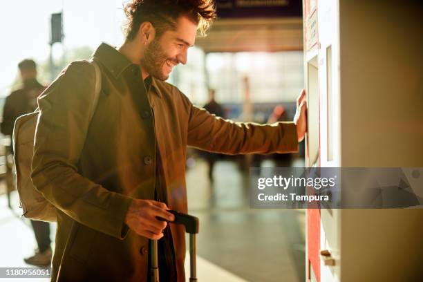 un giovane pendolare che compra i biglietti in una stazione della metropolitana. - biglietteria foto e immagini stock