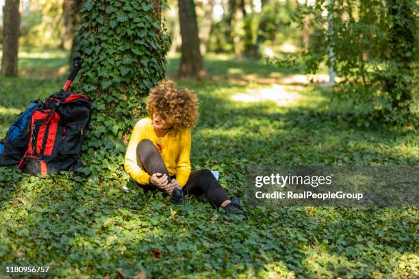 woman are injured at the ankle after hiking. hiking concept. - twisted ankle stock pictures, royalty-free photos & images