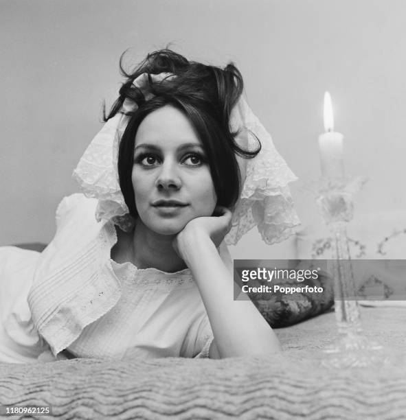 English actress Francesca Annis posed on a bed wearing a lace scarf in her hair at home in December 1966.