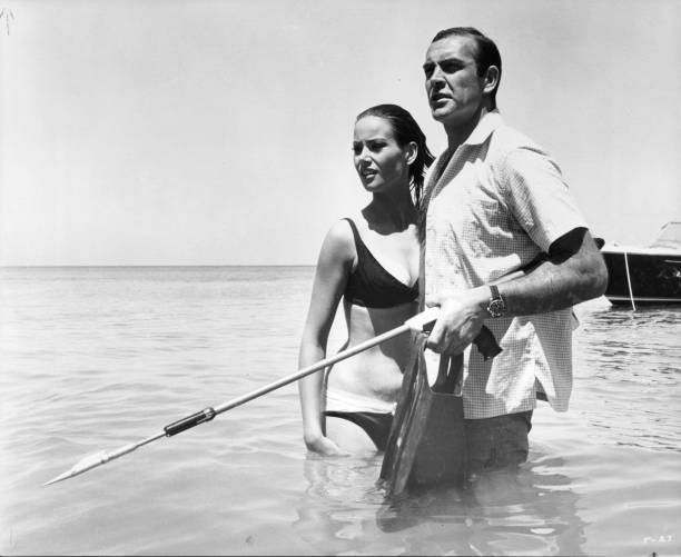 Claudine Auger standing with Sean Connery in the water in a scene from the film 'Thunderball', 1965.