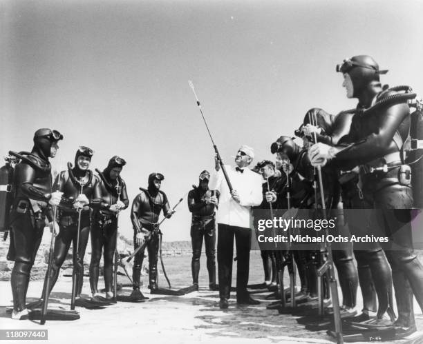 Adolfo Celi shows weapon to divers in a scene from the film 'Thunderball', 1965.