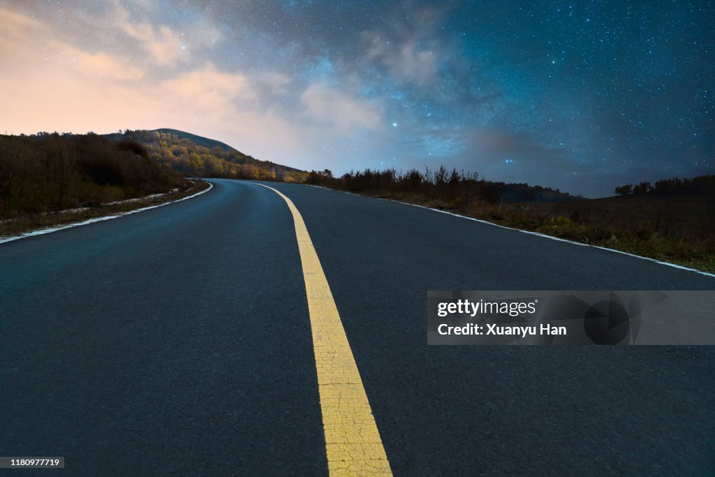 The empty road under the night sky of the Milky Way