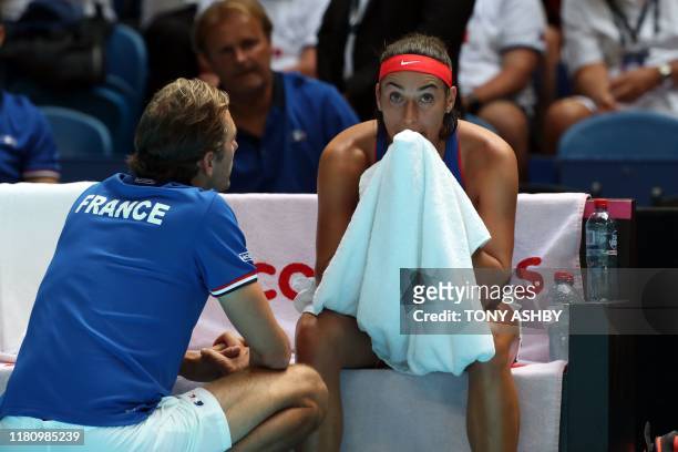 Caroline Garcia of France listens to French team's captain Julien Benneteau during a match against Ashleigh Barty of Australion on day one of the Fed...