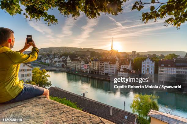 man photographing limmat river at dawn, zurich - zurich foto e immagini stock