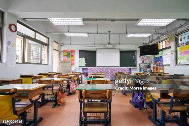 leere schreibtische des klassenzimmers in der grundschule - preschool classroom stock-fotos und bilder