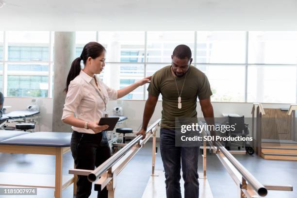 physical therapist guides military vet as he uses injured foot - military veteran armed forces stock pictures, royalty-free photos & images