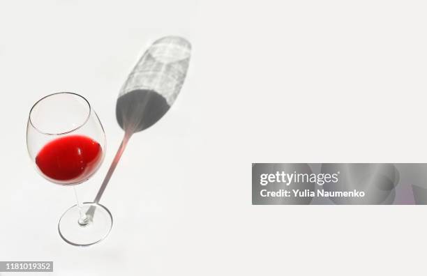 shadow from a glass with red wine on a background. minimal style life with a hard shadow. - merlot grape stock pictures, royalty-free photos & images