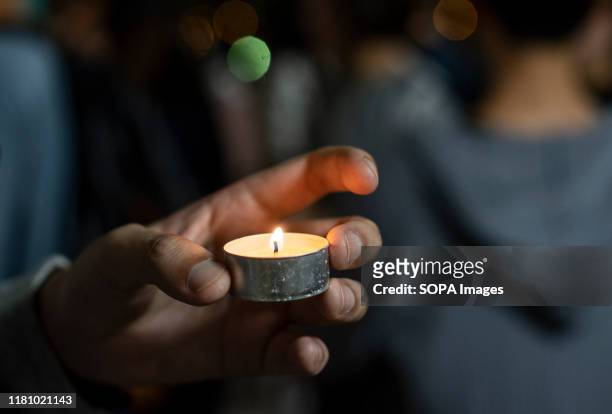 Mourner holds a candle at a memorial ceremony of Chow Tsz-lok a student who fell during a recent protest in Tseung Kwan O, Hong Kong. Chow's death...