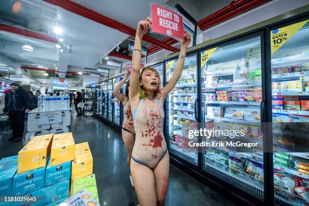 Protester covered in blood marching through Whole Foods. Animal liberation activists with the grassroots animal rights network Direct Action...