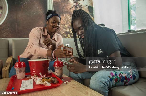 Oumy Kaltoum Sarah Diop, 16 and Khadija Gueye, 17 share a bucket of chicken at KFC in Dakar, Senegal, on October 23, 2019. Sarah first tried KFC in...