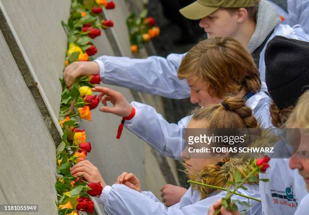Guests place flowers at the Wall Memorial during the central commemoration ceremony for the 30th anniversary of the fall of the Berlin Wall, on...