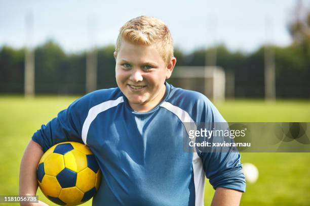 portrait of smiling blond preteen male footballer in spain - chubby teen boy stock pictures, royalty-free photos & images