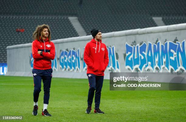 Leipzig's Swedish midfielder Emil Forsberg and Leipzig's Welsh defender Ethan Ampadu inspect a mock-up of the former Berlin Wall bearing the...