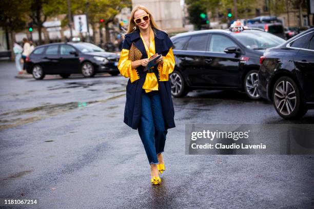 Guest, wearing a yellow blouse, blue vest and blue jeans, is seen outside the Miu Miu show during Paris Fashion Week - Womenswear Spring Summer 2020...