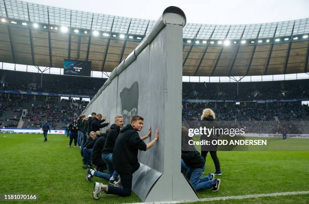 Volunteers prepare to knock over mock-up of the former Berlin Wall bearing the inscrition "Against Walls together with Berlin" standing across the...