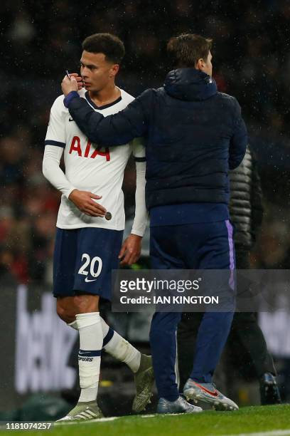 Tottenham Hotspur's English midfielder Dele Alli is substituted by Tottenham Hotspur's Argentinian head coach Mauricio Pochettino during the English...
