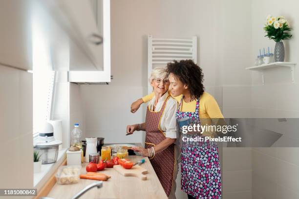home cooked happiness - adult daughter cooking with mom stock pictures, royalty-free photos & images