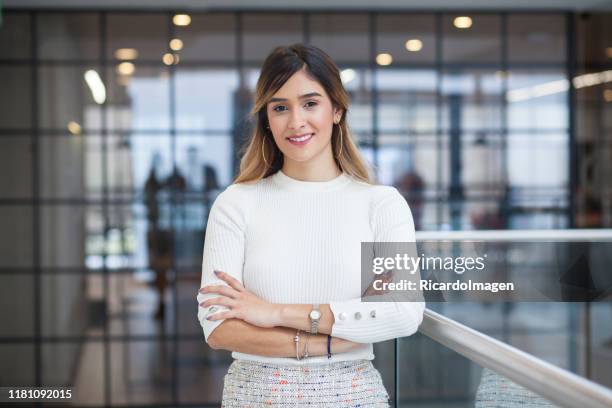 latijn-haired latina vrouw met haar armen gekruist kijken naar de camera terwijl glimlachend - strictly stockfoto's en -beelden