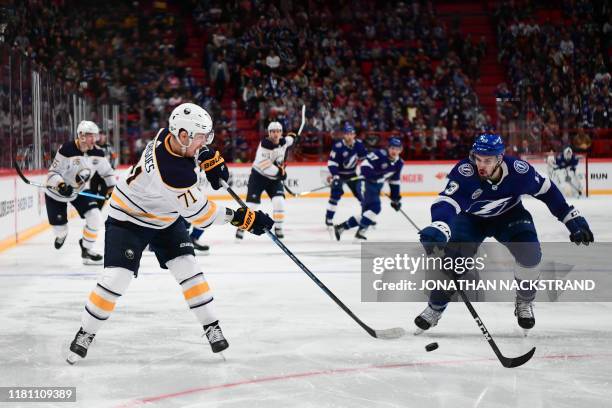 Evan Rodrigues of Buffalo Sabres and Cedric Paquette of Tampa Bay Lightning vie for the puck during the NHL Global Series Ice Hockey match Tampa Bay...