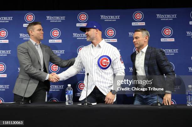 David Ross shakes hands with Theo Epstein as Jed Hoyer looks on at Ross's first news conference as Cubs manager at the American Airlines Conference...