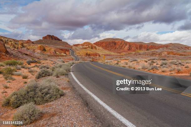 winding road to mountain range - desert road stock pictures, royalty-free photos & images