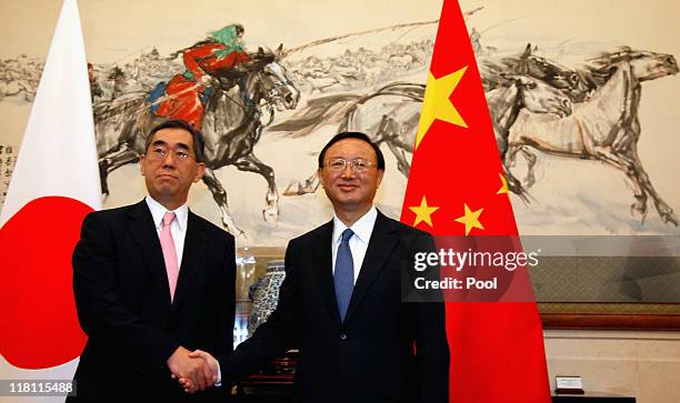 Japanese foreign minister Takeaki Matsumoto shakes hands with Chinese foreign minister Yang Jiechi at the Diaoyutai State guesthouse on July 4, 2011...